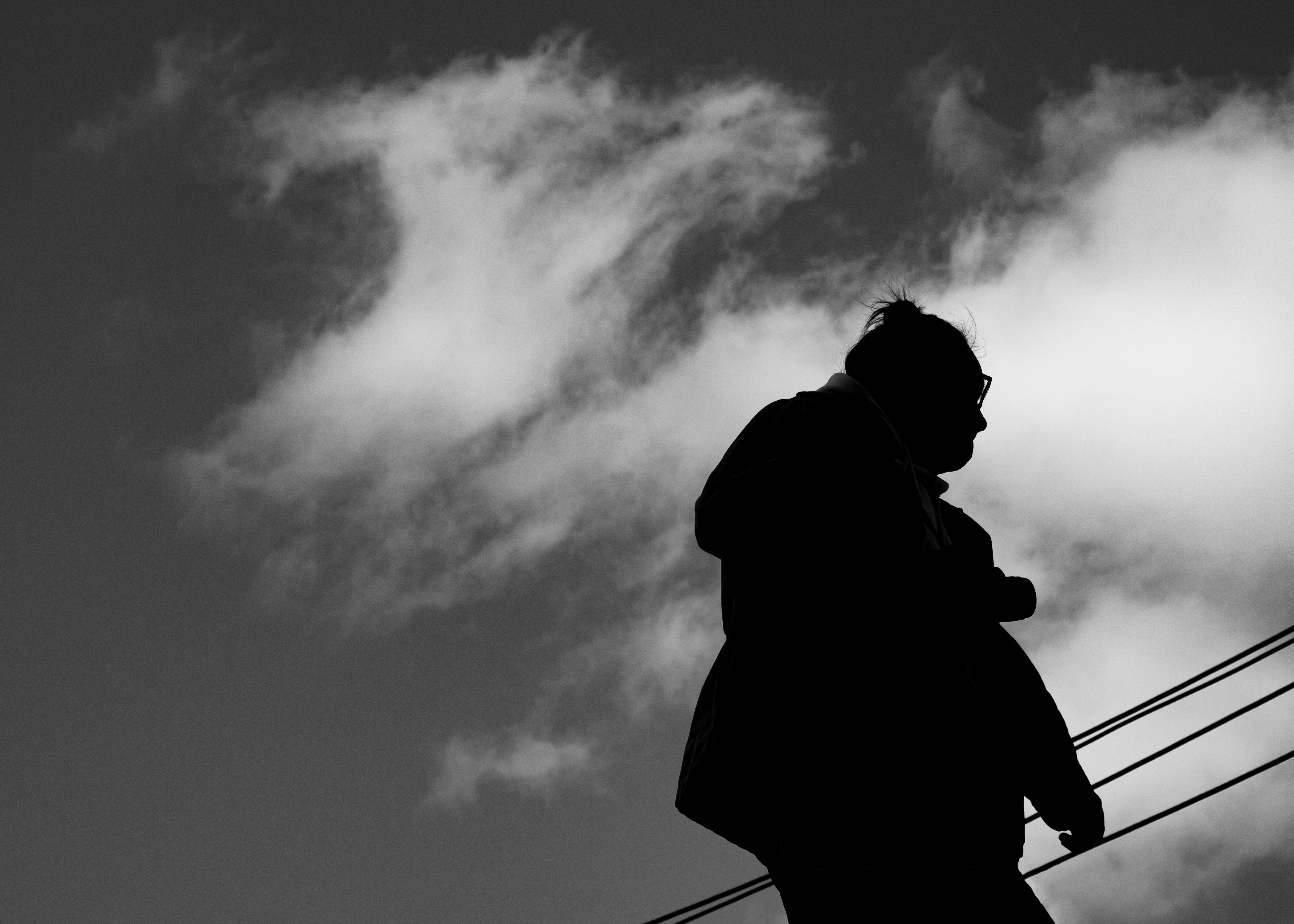 Silhouetted man with power lines and clouds, image by Kyle Knitter